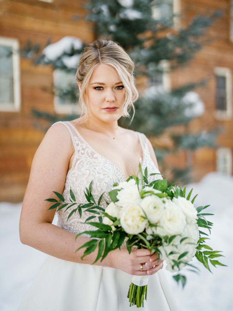 Bridal portraits of bride in front of Sun Valley Lodge in the snow.