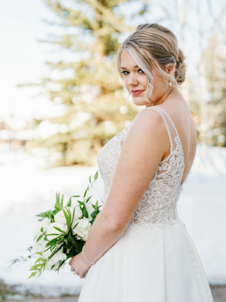 A bride in front of Sun Valley Lodge in the snow before wedding.