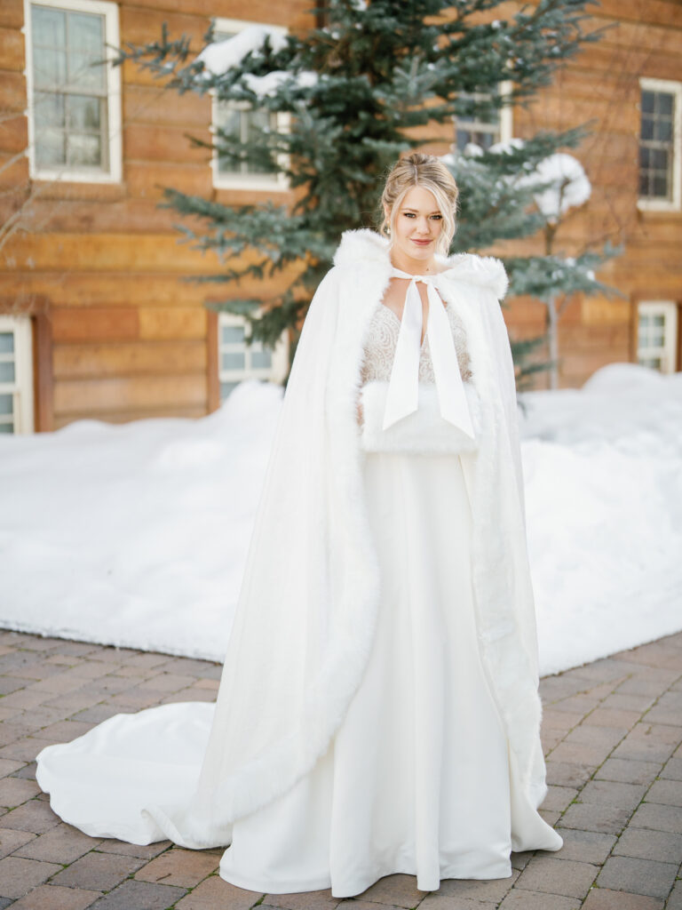 A cozy bride  in front of Sun Valley Lodge in the snow before wedding.