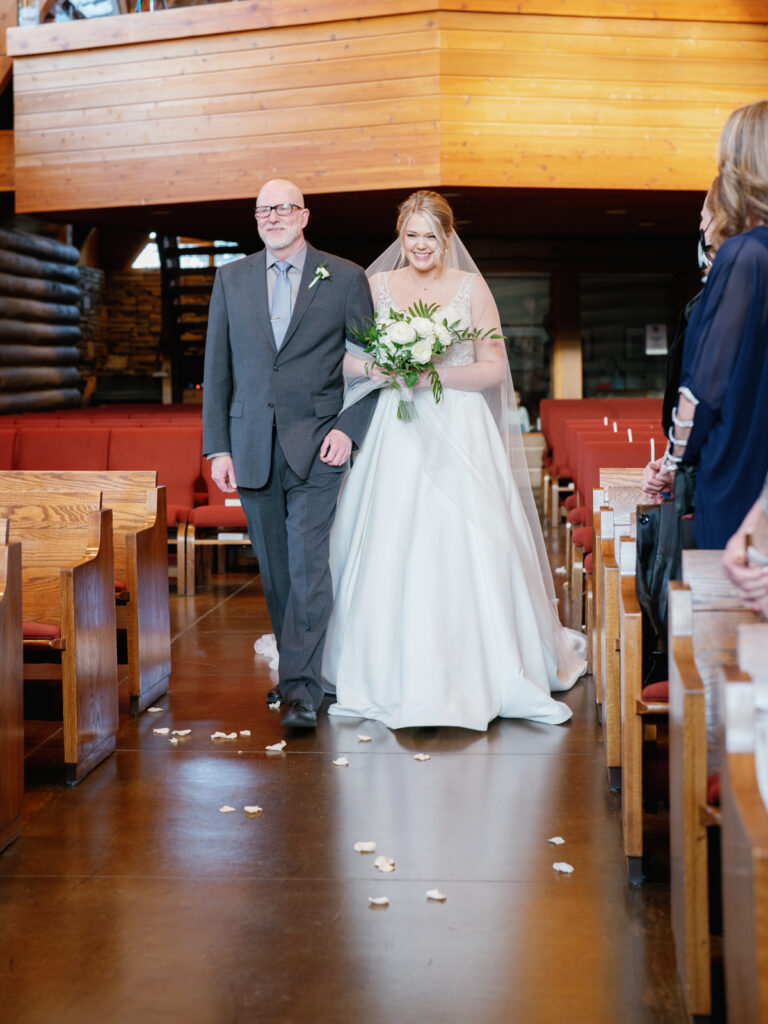 Bride walking down the aisle with father during ceremony at Saint Thomas Episcopal Church in Sun Valley Wedding