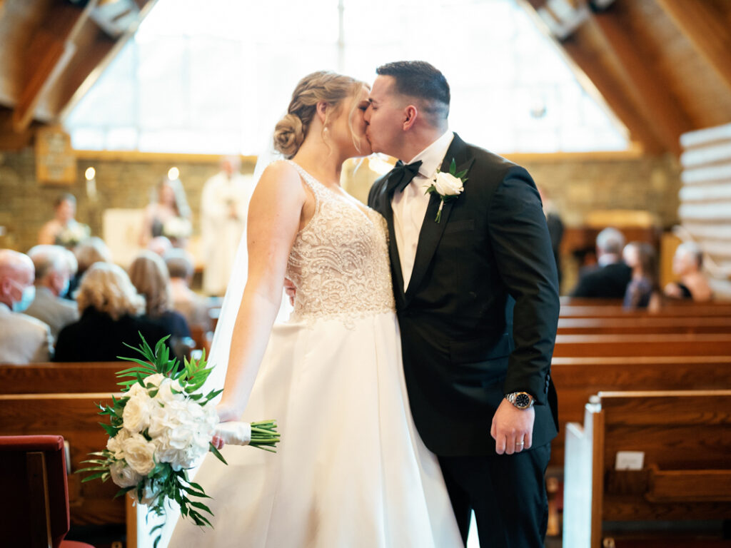 Bride and Groom kiss after end of wedding ceremony at Saint Thomas Episcopal Church in Sun Valley