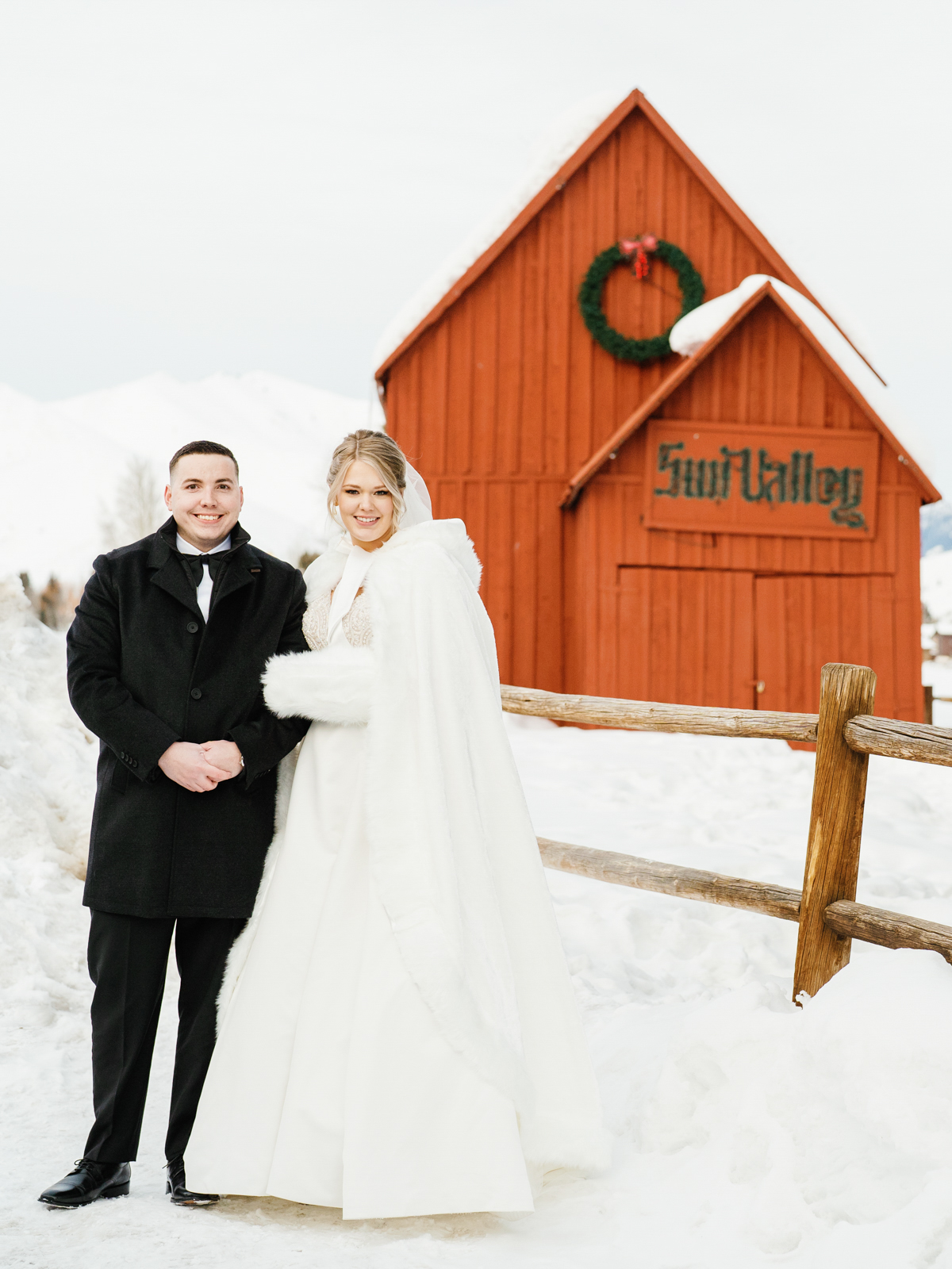 Newlyweds in a Winter Wonderland Sun Valley Wedding in front of the red barn.