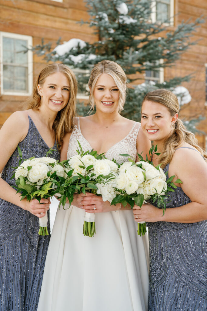 A Bride and Bridesmaids in dresses by BHLDN Weddings in front of Sun Valley Lodge