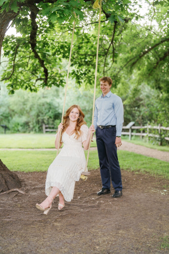 An engaged couple swinging during their engagement session in Boise's Hulls Gulch lower foothills by Bramble and Vine.