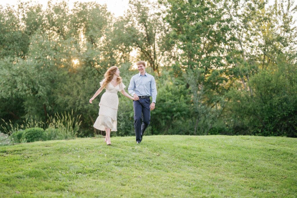 A couple running during their engagement session in Boise's Hulls Gulch lower foothills.  